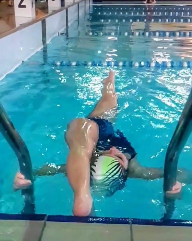 Stretching on the pool ladder.
